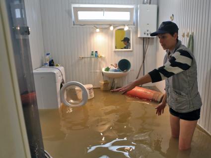 Наводнение в Сочи. Женщина показывает уровень воды в доме.