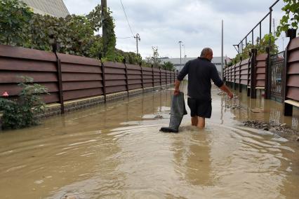 Наводнение в Сочи. Мужчина идет по затопленной улице.