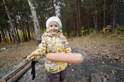 Ребенок с сосиской в осеннем лесу.