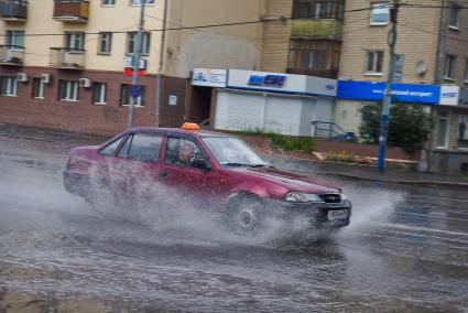 Таксист едет по лужам.