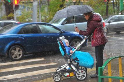 Снег в Москве. На снимке: женщина с ребенком в коляске.