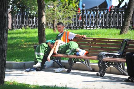 Усталость. На снимке: мужчина и женщина в рабочей одежде отдыхают на лавочке.