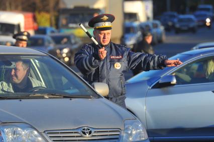 На снимке: сотрудник ДПС регулирует движение транспорта в Отрадном.