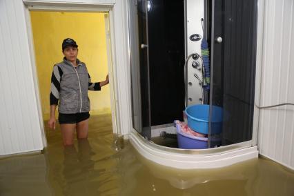 Наводнение в Сочи. На снимке: женщина в затопленном водой жилом доме.