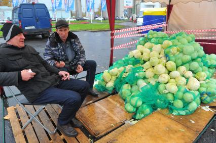 Ярмарка на ВВЦ. На снимке: мужчина торгует белокочанной капустой.