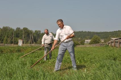 Село Кушья. На снимке: аместитель редактора отдела международной и внутренней политики КП Александр Гамов и президент Удмуртии Александр Волков (слева направо) косят траву.