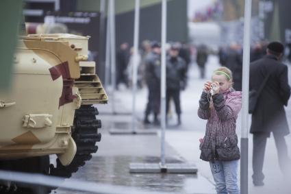 Выставка вооружения, военной техники и боеприпасов \"Российская выставка вооружения. Нижний Тагил - 2013\" (Russia Arms Expo - RAE). На снимке:  девочка фотографирует военную технику