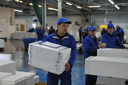 Профессиональная продажа морепродуктов и охлажденной рыбы. Склад рыбной продукции компании `La Maree`. На снимке: рабочий с коробками