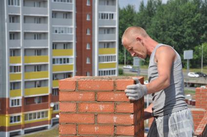 Строительство жилого комплекса `Полесье` в поселке Октябрьском. На снимке:  строитель .