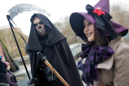 Юноша в костюме смерти и девушка в костюме ведьмы.