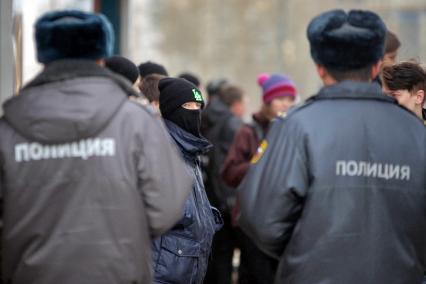 Подросток в балаклаве напротив двух полицейских.