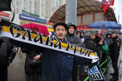 День народного единства. Улица Перерва. На снимке: митингующий держит имперский шарф `Слава Руси` во время акции `Русский марш` в Люблино.