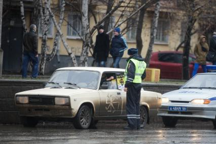 Русский марш в Екатеринбурге. На снимке: полицейский остановил автомобиль чтобы водитель снял имперский флаг.