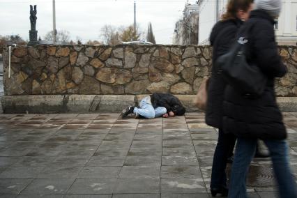 Бездомный спит на улице.