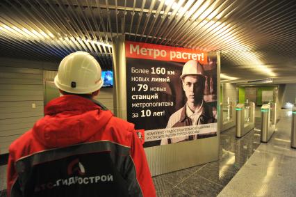 Открытие станции метро `Жулебино`. На снимке: рабочий ЗАО `Гидрострой` и  рекламный плакат с надписью `Метро растет!`