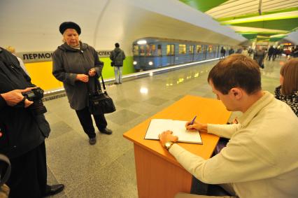 Открытие станции метро `Лермонтовский проспект`. На снимке: пассажир метрополитена делает запись в книге отзывов.