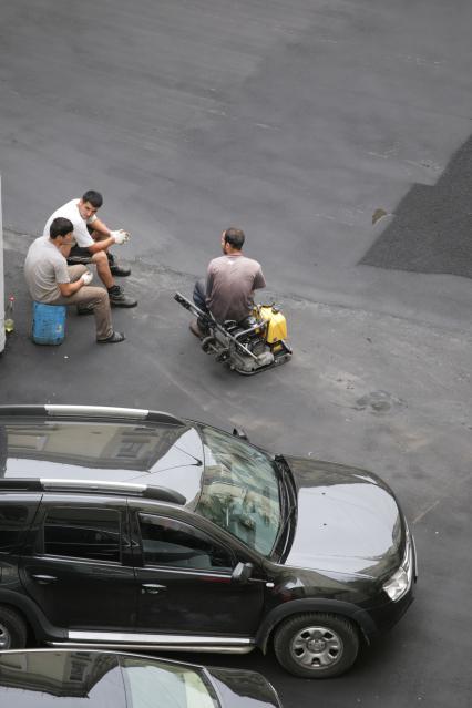 Улица Большая Дмитровка. Дорожно-ремонтные работы по замене асфальта. На снимке: рабочие во время отдыха.