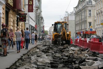 Улица Большая Дмитровка. Дорожно-ремонтные работы по замене асфальта. На снимке: экскаватор-погрузчик.