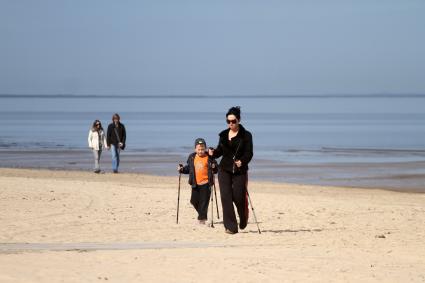 Люди гуляют по берегу Балтийского моря в Юрмале.