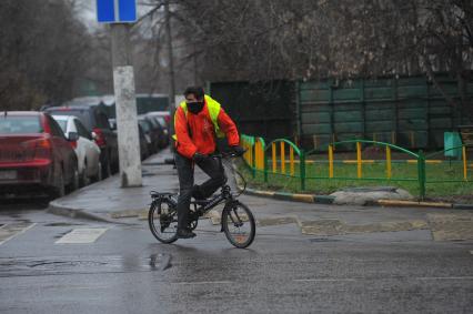 Дождь в городе. На снимке: велосипедист на дороге.