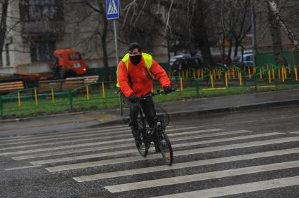 Дождь в городе. На снимке: велосипедист на пешеходном переходе.