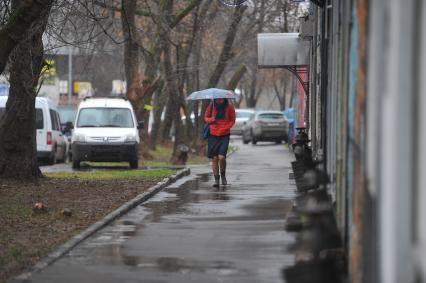 Дождь в городе. На снимке:девушка под зонтом