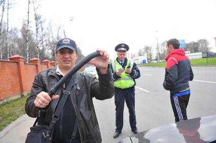 Сотрудники ДПС провели операцию `Осмотр и досмотр автомобилей` на Мичуринском проспекте. На снимке: корреспондент КП Владимир Демченко держит в руках изъятую у водителя резиновую дубинку.