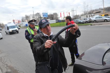 Сотрудники ДПС провели операцию `Осмотр и досмотр автомобилей` на Мичуринском проспекте. На снимке: корреспондент КП Владимир Демченко держит в руках изъятую у водителя резиновую дубинку.