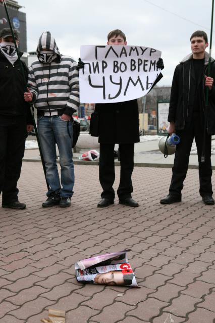 Митинг против засилья гламура в СМИ, организованный политической организацией `Евразийский союз молодежи` на Триумфальной площади. На снимке: активист держит плакат `Гламур-пир во время чумы`.