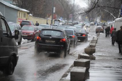 Тающий снег в Москве. На снимке: автомобили едут по лужам.