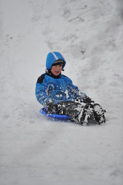 Снег в Москве. На снимке: ребенок скатывается с горки.