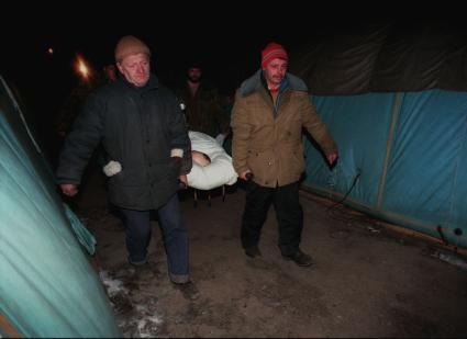 Начало первой чеченской войны. На снимке: мужчины несут раненого на носилках.