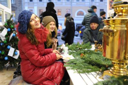 Станция `Теплое место` открылась в Столешниковом переулке. На снимке: девушки едят за столом.