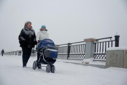 Снегопад в Екатеринбурге. На снимке: Женщины с коляской прогуливаются по набережной.