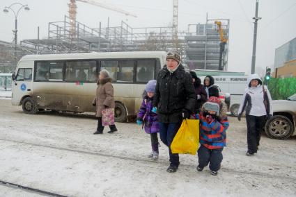 Снегопад в Екатеринбурге. На снимке: женщина с детьми переходит дорогу.