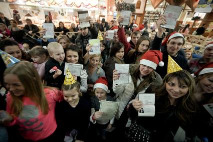 Акция празднования дня рождения для тех, кто родился 31 декабря. На снимке: Взрослые и дети показывают свои документы.