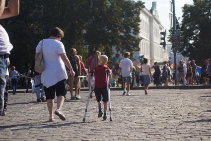 День города в Екатеринбурге. На снимке: мальчик на костылях идет по городу.