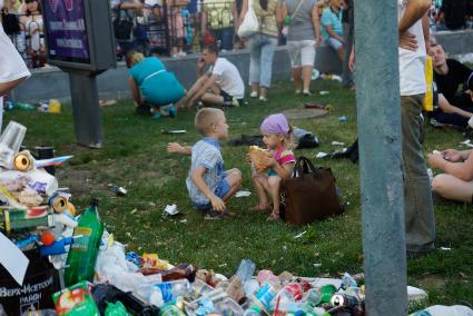 День города в Екатеринбурге. На снимке: двое детей кушают хлеб в окружении гор мусора.