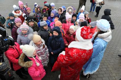 Новогодняя акция КП на смотровой площадке Воробьевых гор. На снимке: корреспондент КП Олег Адамович и телеведущая КП Арина Горшкова раздают подарки детям.