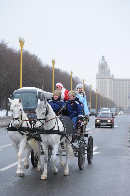 Новогодняя акция КП на Воробьевых горах. На снимке: корреспондент КП Олег Адамович и телеведущая КП Арина едут с новогодними подарками в повозке.