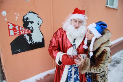 Дед Мороз и Снегурочка распивают спиртные напитки. На стене надпись `Хватит бухать`.
