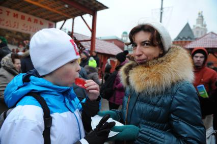 Стокилограммовый леденец в виде лошади, приготовленный тверскими кондитерами установлен на Площади Революции.  На снимке: дети и взрослые дегустируют леденец.