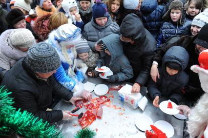 Стокилограммовый леденец в виде лошади, приготовленный тверскими кондитерами установлен на Площади Революции. На снимке: дети и взрослые дегустируют леденец.