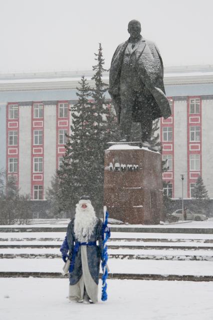 Дед Мороз позирует у памятника Владимиру Ленину.