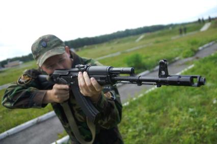 Боец выполняет стрельбу из положения сидя.