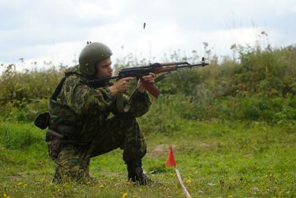 Боец выполняет стрельбу из положения сидя.