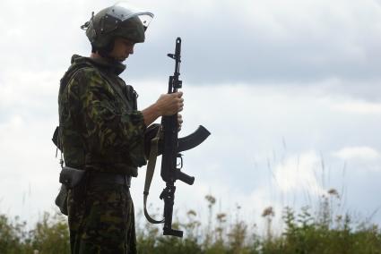 Боец готовится выполнять стрельбу из автомата.