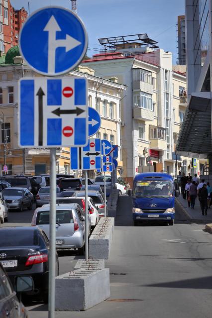 Большое скопление автомобильных дорожных знаков на улице.