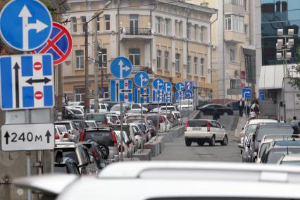 Большое скопление автомобильных дорожных знаков на улице.