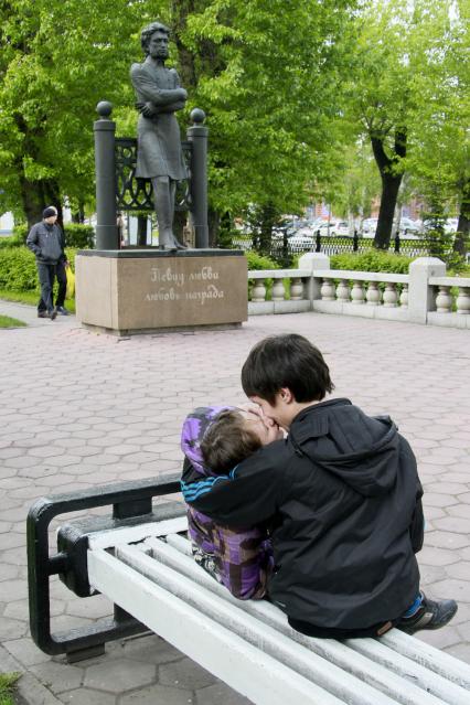 Парочка целуется на скамейке около памятнику А.С. Пушкину.